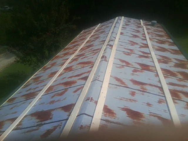 Rusted metal roof panels with new wood purlins before replacement — Storm Damage Roof Repair in Earlsboro by Roofing Brothers