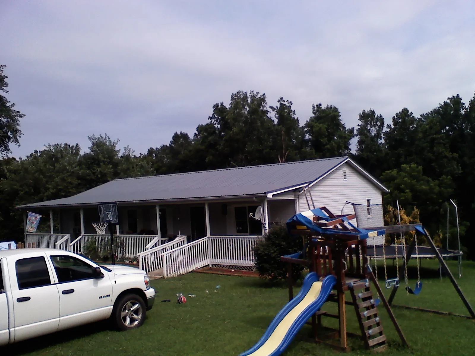 Dark metal roof on a country home with a full length front porch in Earlsboro