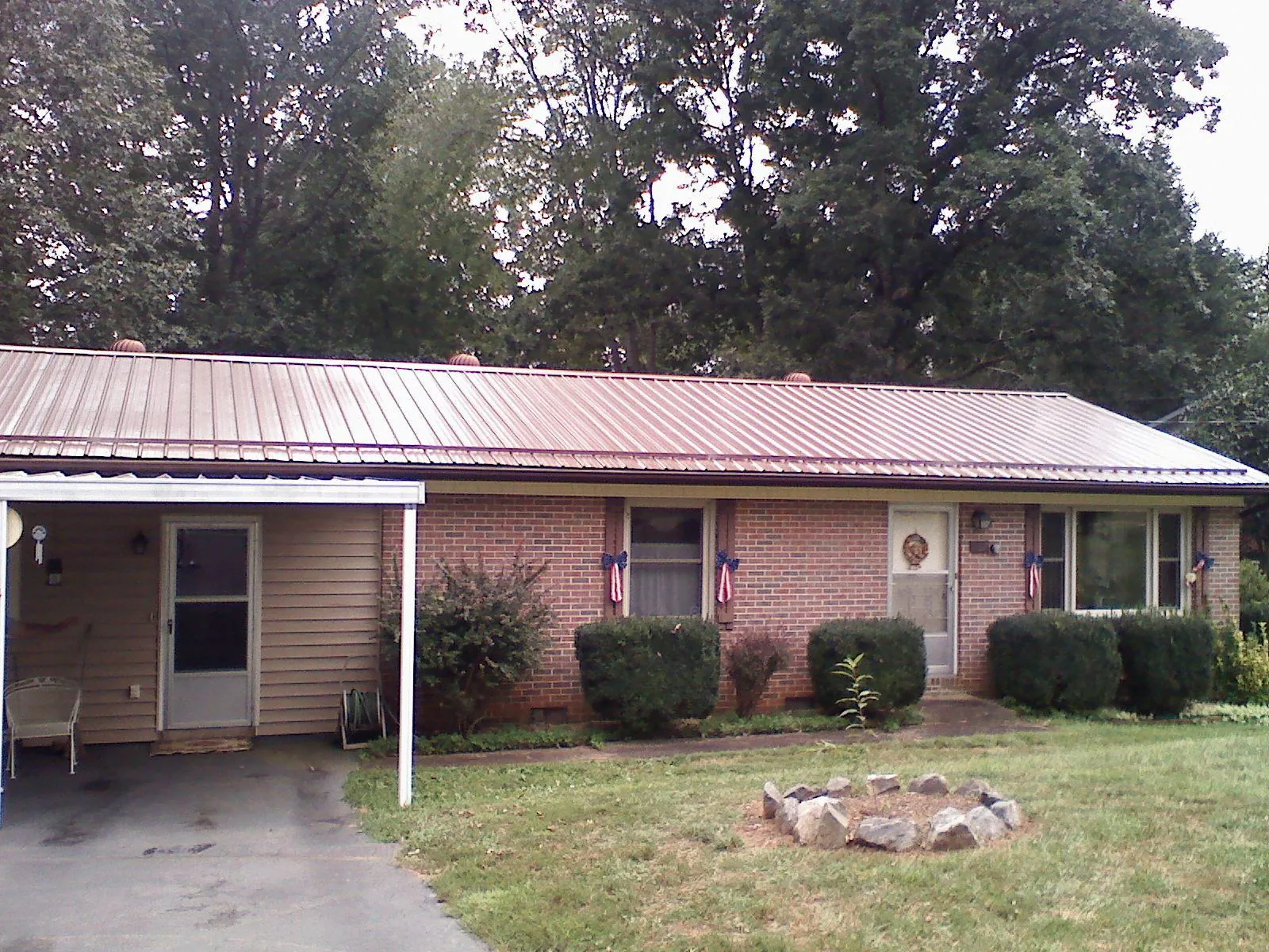 Bronze metal roof and carport on a brick ranch home — Roof Repair work by our crew in Earlsboro