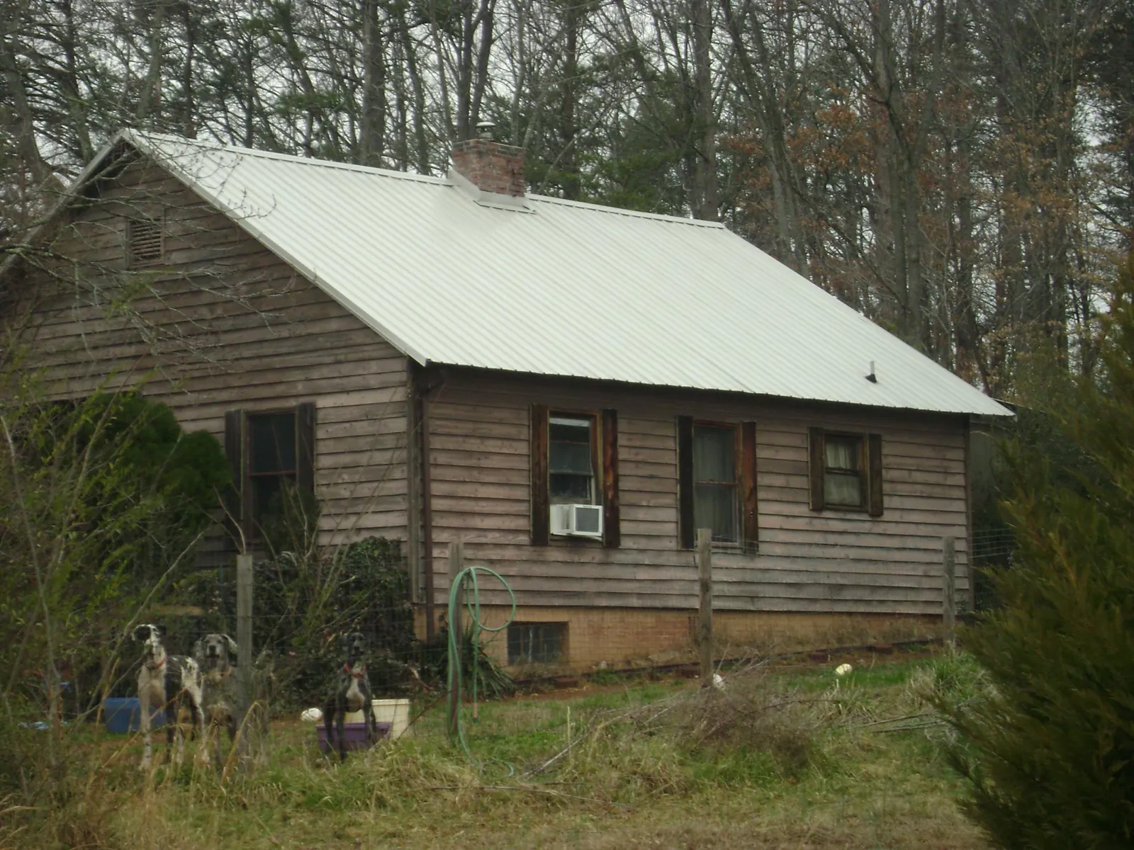 White metal roof on an old wood sided farmhouse, from a Metal Roof Installation job in Earlsboro